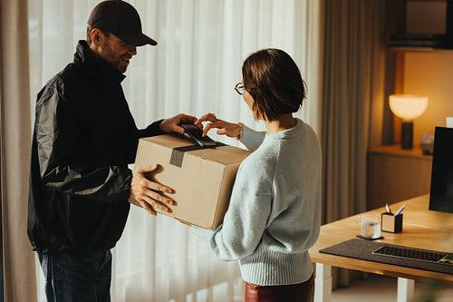 Woman signs for package delivery at the workplace