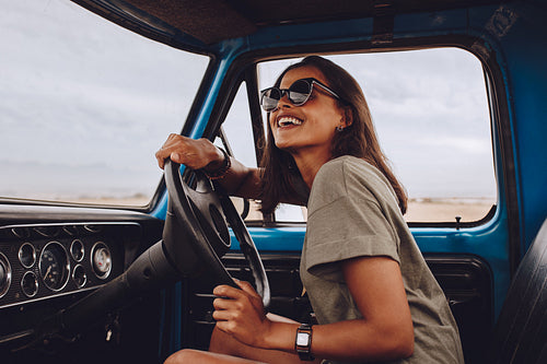 Woman on road trip driving a car and smiling