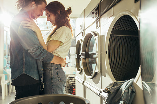 Intimate couple standing in laundry room