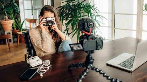 Female blogger photographing her content on a camera