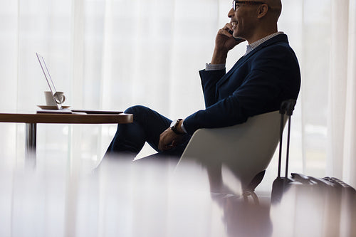 Business traveler making a phone call from airport lounge