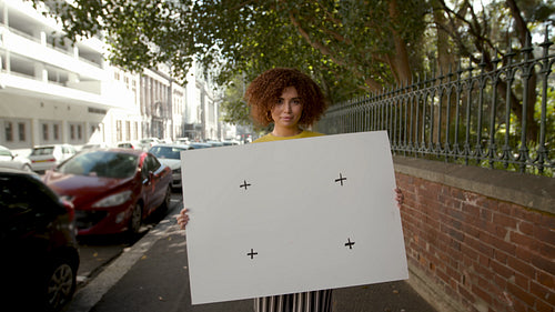 Beautiful woman with a blank billboard on sidewalk