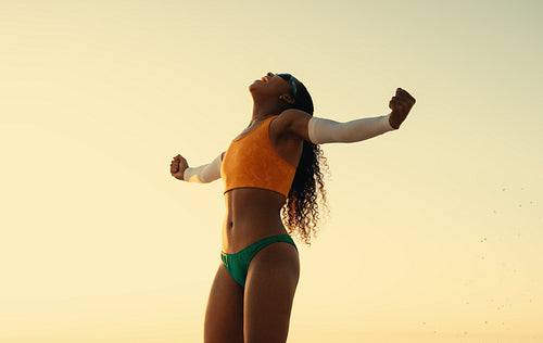 Victorious brazilian athlete celebrating beach volleyball championship at sunset