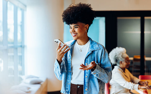 Happy woman chats on phone in denim jacket