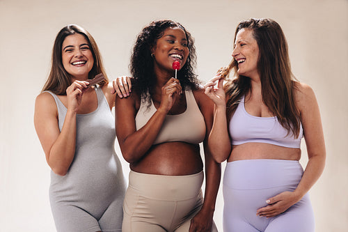 Multicultural pregnant women enjoying sweets and candy, satisfying their pregnancy cravings