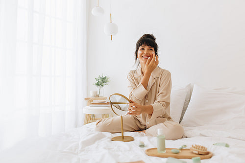 Smiling woman doing skin care at home