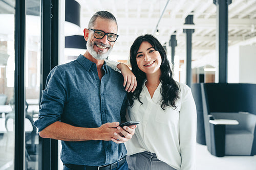 Cheerful colleagues smiling at the camera in the office
