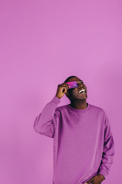 Credit card holding student smiles happily in a studio