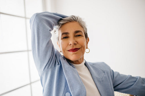 Successful business woman looking at the camera in an office, wearing a professional suit