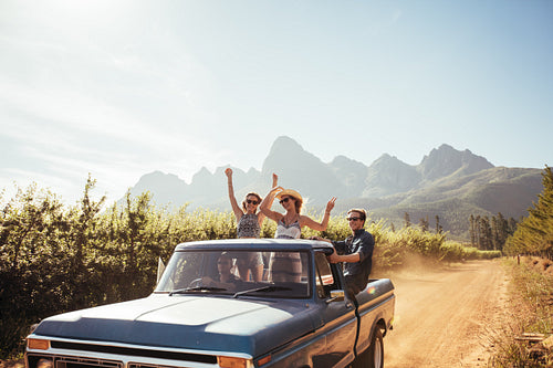 Group of young friends riding in pickup truck