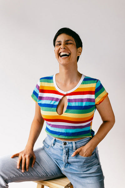 Laughing queer woman sitting in a studio