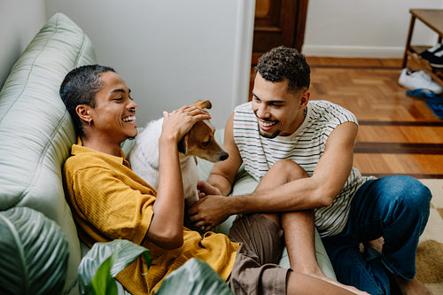 Loving couple enjoying time with their dog on a cozy home sofa