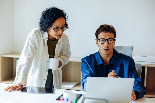 Business people discuss project at an office desk