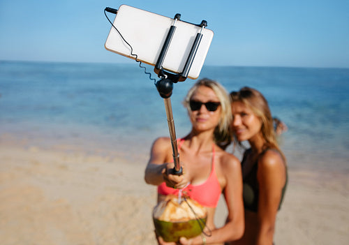 Women friends on beach holiday taking selfie