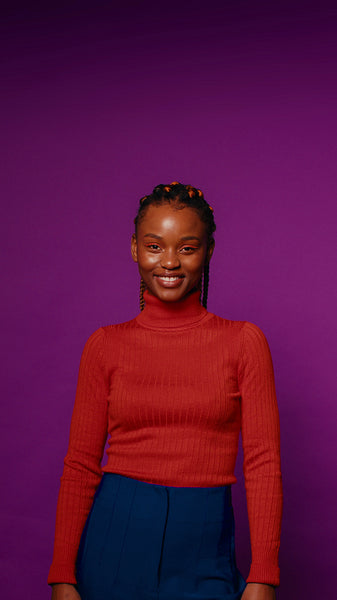 Young woman laughs on purple background in studio