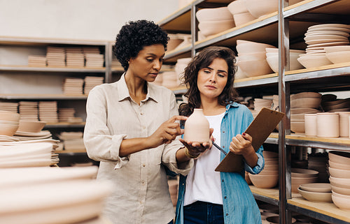 Ceramists discussing one of their handmade products