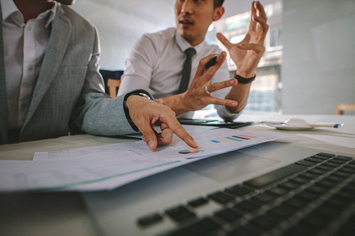 Business people discussing over some statistical analysis