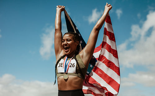 Runner celebrating victory with american flag