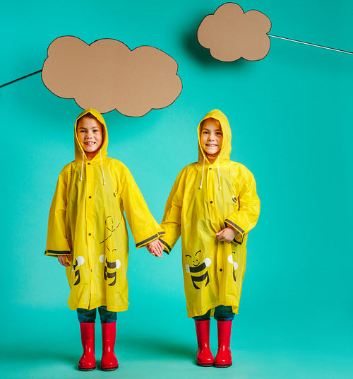 Twin sisters in raincoats
