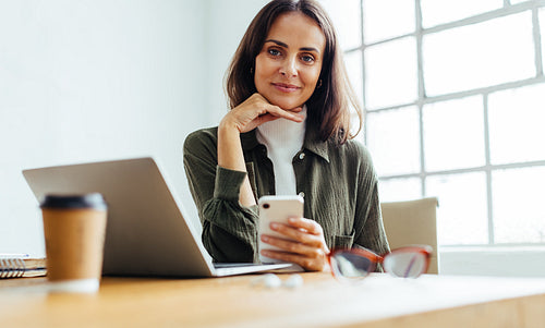 Portrait of a female entrepreneur sitting at her work desk