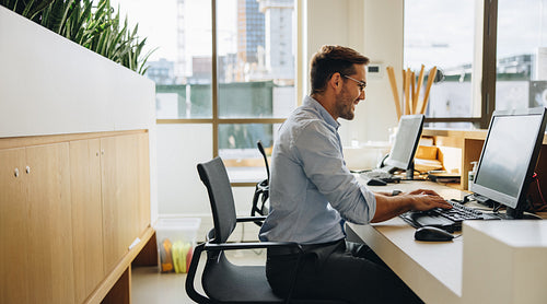 Smiling young man working at his desk
