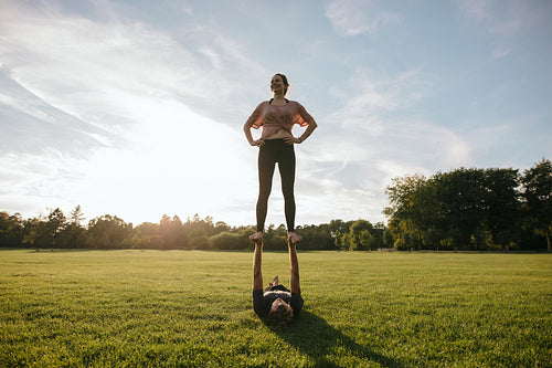 Couple practicing acrobatic yoga in park
