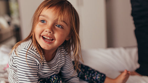 Little girl playing on bed