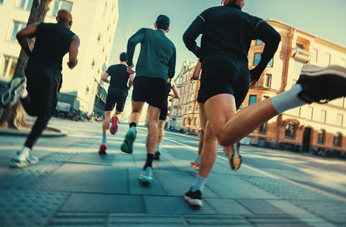 Team running through the city highlights fitness and run club culture