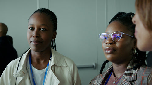 Diverse businesswomen engaging in a lively conversation at a professional conference or event