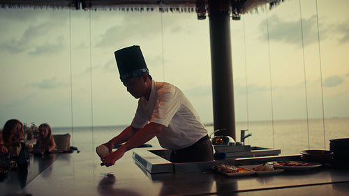 Family enjoys a captivating teppanyaki chef performance and fine dining experience by the sea