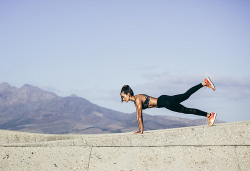 Muscular young woman doing push ups