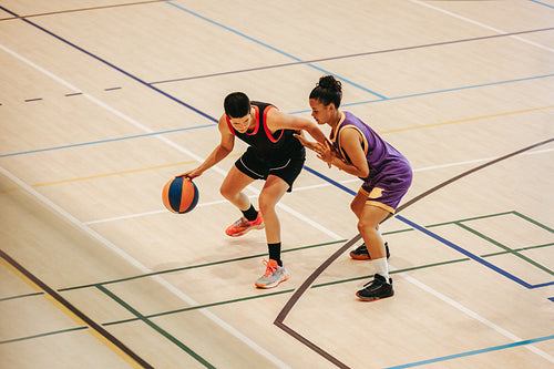 Determined to win: Female basketball player dribbles under pressure