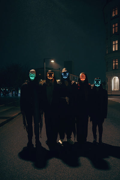 Group wearing glowing masks at night on a city street