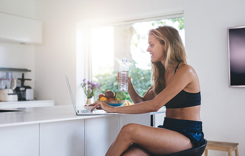 Beautiful woman using laptop computer in the kitchen