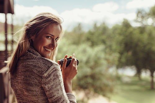 Smiling woman having coffee in morning
