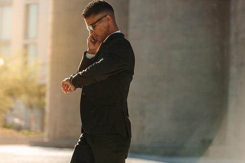 Man using mobile phone while walking on street