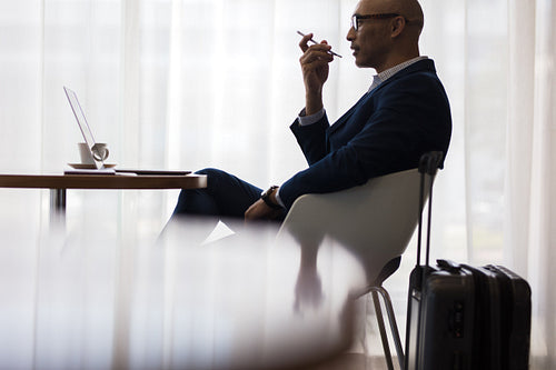 Businessman speaking on mobile phone at airport lounge
