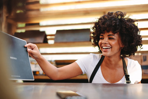 Woman displaying menu card at the counter