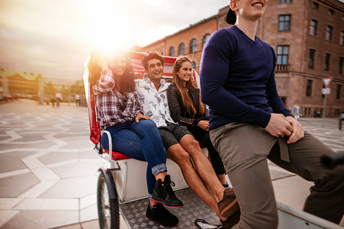 Teenagers riding on tricycle and having fun