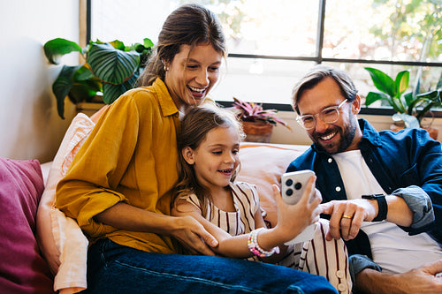Family moment: parents and daughter enjoy video call at home