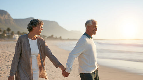 Senior couple walking together on the beach