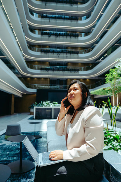 Businesswoman talking on phone in modern office courtyard