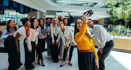 Diverse group of new hires taking a fun office selfie together