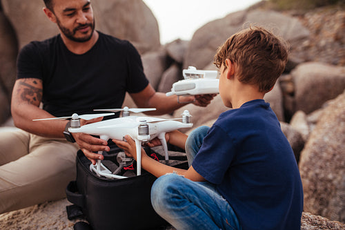 Young man with his son at the beach with a drone