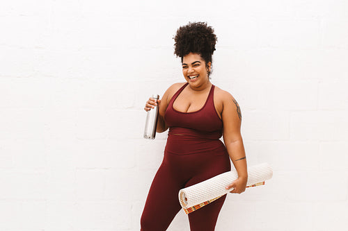 Healthy female with yoga mat and water bottle