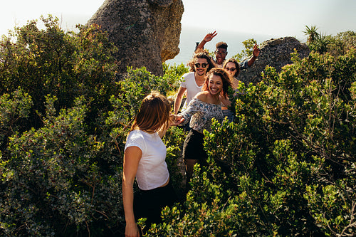 Group of friends walking through a mountain trail