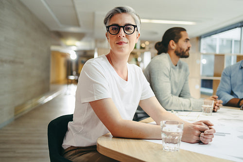 Mature design professional attending a meeting with her team