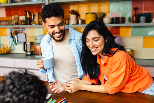 Smiling Latino couple spending quality time with family in a colorful kitchen