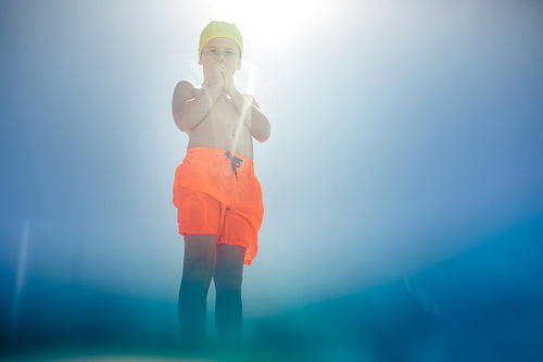 Boy in swimming costume at outdoor pool