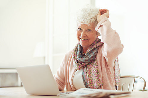 Cheerful Grandmother at Home with Laptop